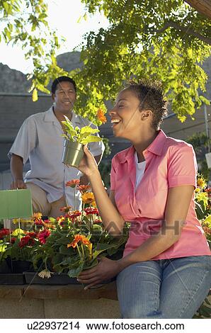 Woman smelling flowers at plant nursery View Large Photo Image Picture - Woman smelling flowers at plant nursery. Fotosearch