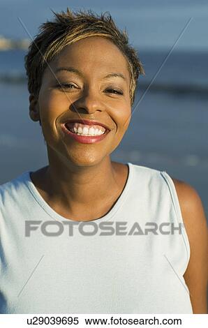 Woman smiling on beach, (close-up), (portrait) View Large Photo Image Stock Photography - Woman smiling on beach, (close-up), (portrait). Fotosearch