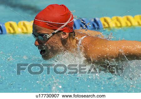 Stock Photo - Woman swimming butterfly stroke, (close-up). Fotosearch