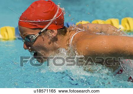 Stock Photography - Woman swimming butterfly stroke, (close-up). Fotosearch