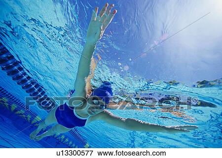 Woman swimming floating underwater, (low angle view) View Large Photo Image Stock Photo - Woman swimming floating underwater, (low angle view). Fotosearch