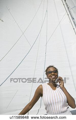 Stock Photo - Woman Using Cell Phone on Yacht. Fotosearch