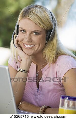 Stock Photography - Woman Using Laptop Wearing Telephone Headset. Fotosearch