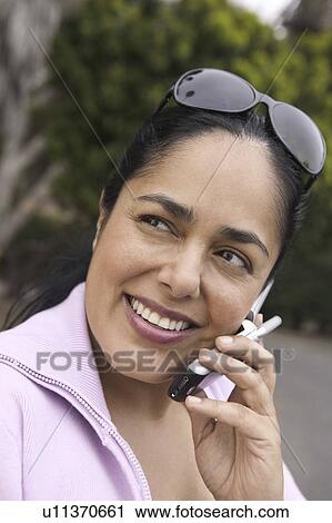Stock Image - Woman using mobile phone, outdoors. Fotosearch