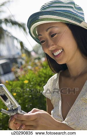 Stock Photography - Woman using mobile phone outdoors. Fotosearch