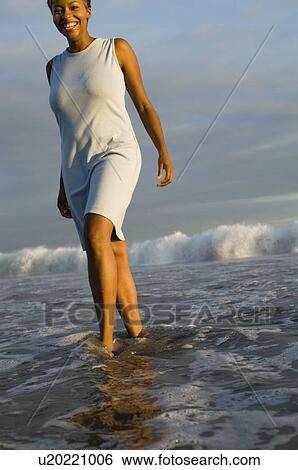 Woman walking through surf View Large Photo Image Stock Photograph - Woman walking through surf. Fotosearch