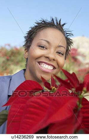 Stock Photo - Woman with Poinsettia, (close-up), (portrait). Fotosearch