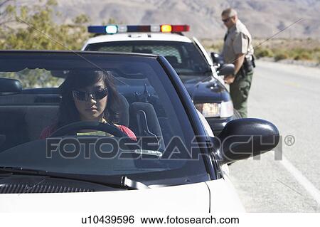 Women sitting in car being pulled over by police officer View Large Photo Image Stock Photograph - Women sitting in car being pulled over by police officer. Fotosearch
