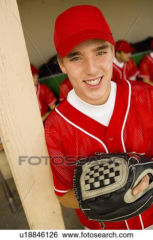 Stock Photograph - Young baseball player on field, smiling, (portrait), (elevated view). Fotosearch