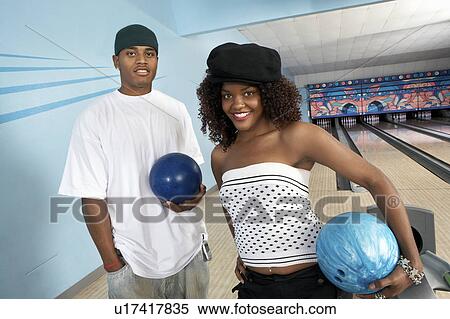 Young couple at bowling alley holding balls, portrait View Large Photo Image Stock Photography - Young couple at bowling alley holding balls, portrait. Fotosearch