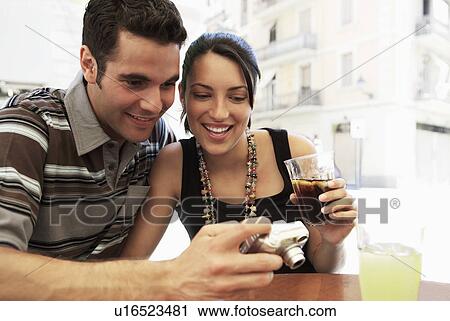 Stock Image - Young couple at cafe looking at camera together, portrait. Fotosearch