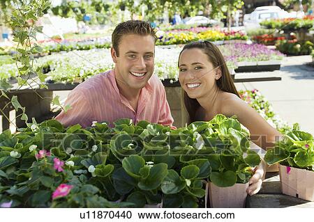 Young couple choosing potted flowers in garden centre, (portrait) View Large Photo Image Stock Image - Young couple choosing potted flowers in garden centre, (portrait). Fotosearch