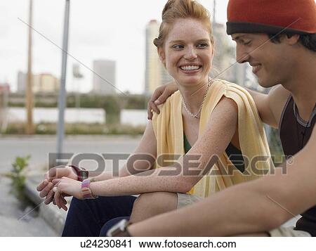 Stock Image - Young couple embracing in street. Fotosearch