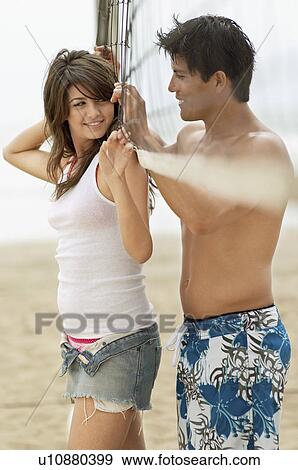 Young couple Flirting on Beach with volleyball net View Large Photo Image Stock Photo - Young couple Flirting on Beach with volleyball net. Fotosearch