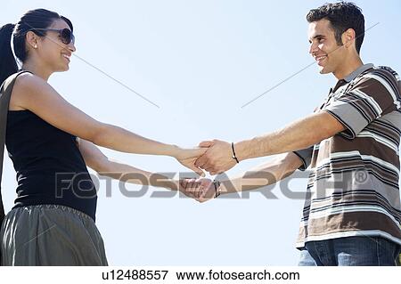 Stock Photo - Young couple holding hands, portrait. Fotosearch