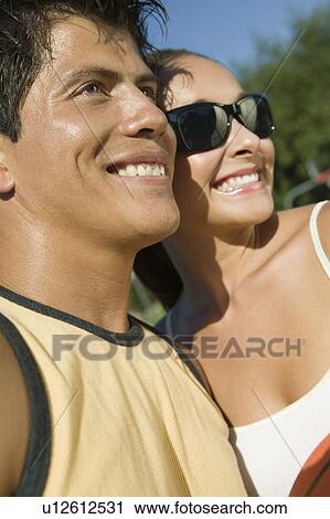 Stock Image - Young Couple outdoors, smiling.. Fotosearch