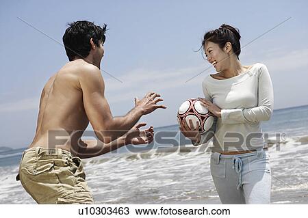 Young couple playing with Volleyball on beach View Large Photo Image Stock Image - Young couple playing with Volleyball on beach. Fotosearch