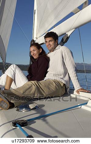 Young couple sitting on sailboat View Large Photo Image Stock Photo - Young couple sitting on sailboat. Fotosearch