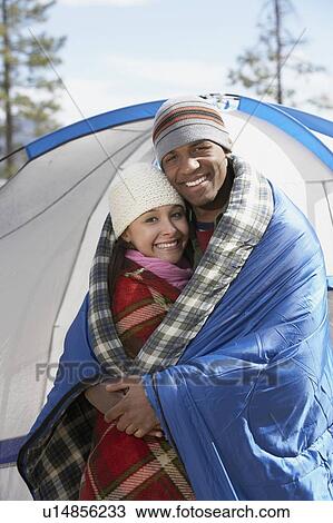 Young couple standing at campsite, wrapped in blankets. View Large Photo Image Stock Image - Young couple standing at campsite, wrapped in blankets.. Fotosearch
