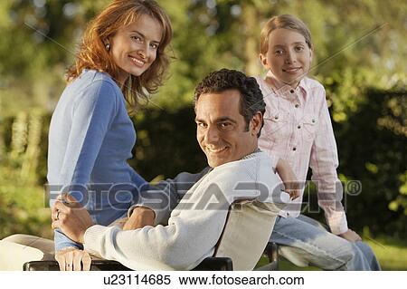 Stock Photography - Young girl with parents in back yard, portrait. Fotosearch