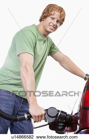 Young man filling car with gas View Large Photo Image Stock Image - Young man filling car with gas. Fotosearch