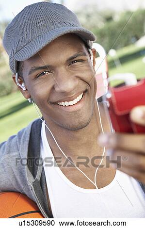 Stock Image - Young Man Listening to mp3 player, portrait. Fotosearch