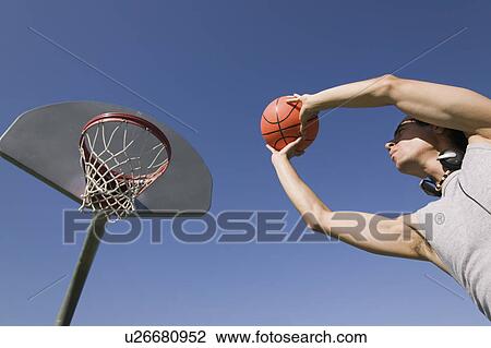 Young man playing basketball, low angle view. View Large Photo Image Stock Image - Young man playing basketball, low angle view.. Fotosearch
