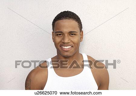 Stock Image - Young Man smiling, portrait, head and shoulders. Fotosearch