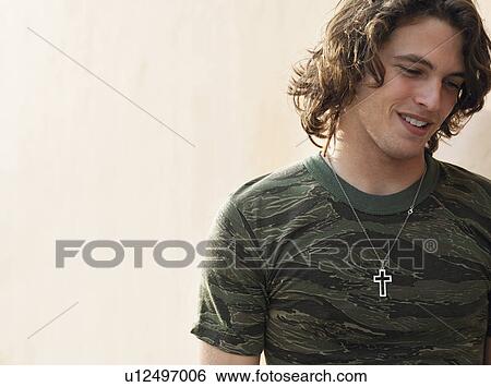 Young man wearing cross shape necklace, outdoors View Large Photo Image Stock Photograph - Young man wearing cross shape necklace, outdoors. Fotosearch