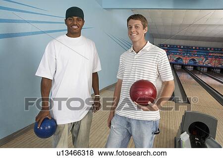 Young men at bowling alley holding balls, portrait View Large Photo Image Stock Photo - Young men at bowling alley holding balls, portrait. Fotosearch