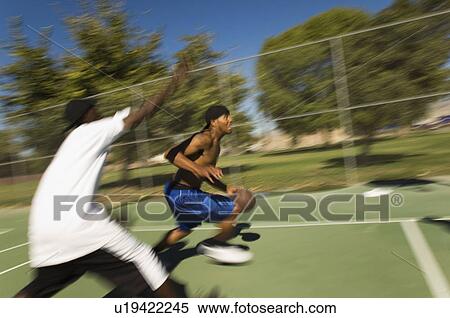 Stock Photography - Young men playing basketball. Fotosearch