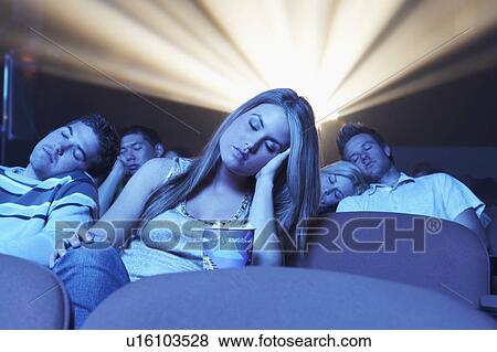 Stock Photo - young People sleeping, head on hand, shoulder in Movie Theatre. Fotosearch