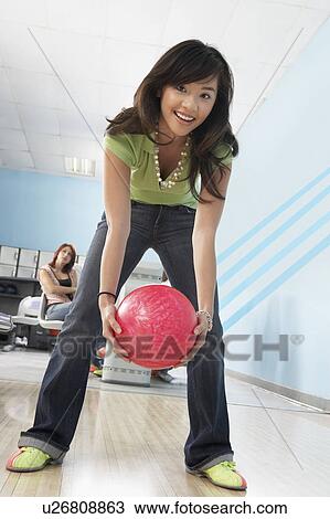 Young woman at bowling alley holding ball, portrait View Large Photo Image Stock Image - Young woman at bowling alley holding ball, portrait. Fotosearch