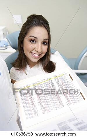 Stock Photo - Young woman at dentists, smiling, (portrait). Fotosearch