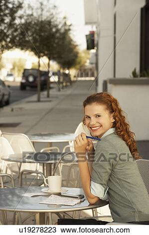 Young woman at outdoor cafe, portrait View Large Photo Image Stock Image - Young woman at outdoor cafe, portrait. Fotosearch