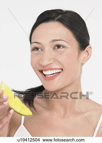 Picture - Young Woman Eating Honeydew Melon, close up. Fotosearch