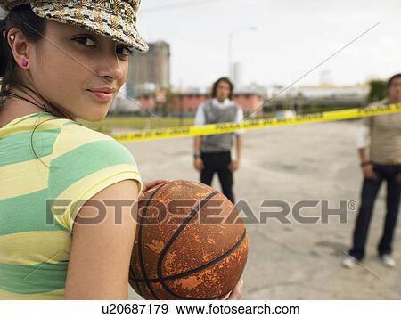 Young Woman holding basketball in street, portrait View Large Photo Image Stock Photo - Young Woman holding basketball in street, portrait. Fotosearch