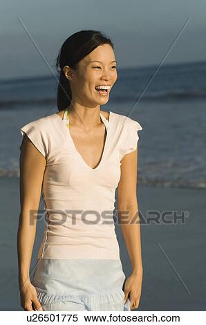 Young woman laughing on beach View Large Photo Image Stock Photography - Young woman laughing on beach. Fotosearch