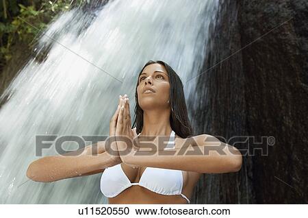 Young woman meditating by waterfall, low angle view View Large Photo Image Stock Image - Young woman meditating by waterfall, low angle view. Fotosearch