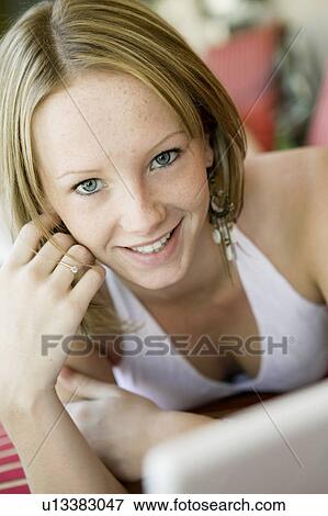 Stock Photo - Young woman on lying on deckchair, portrait, close up. Fotosearch