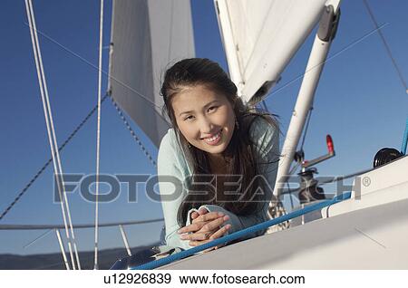Stock Photo - Young woman on sailboat, (portrait). Fotosearch