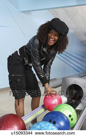 Young woman selecting bowling ball, portrait View Large Photo Image Picture - Young woman selecting bowling ball, portrait. Fotosearch