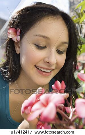 Young woman smelling exotic plat in greenhouse, (close-up) View Large Photo Image Stock Photo - Young woman smelling exotic plat in greenhouse, (close-up). Fotosearch