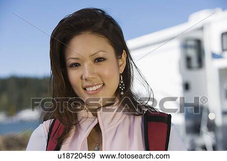 Stock Photo - Young woman smiling outdoors. Fotosearch
