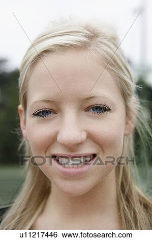 Stock Photograph - Young Woman smiling outside, close-up, portrait. Fotosearch