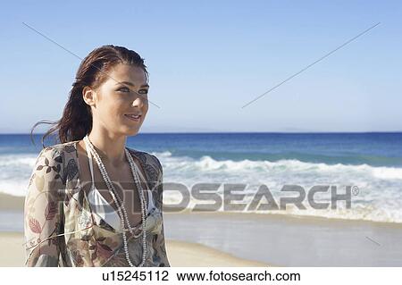 Young woman standing on beach, head and shoulders View Large Photo Image Stock Image - Young woman standing on beach, head and shoulders. Fotosearch