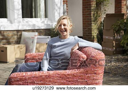 Stock Photo - Young woman taking a break from moving. Fotosearch