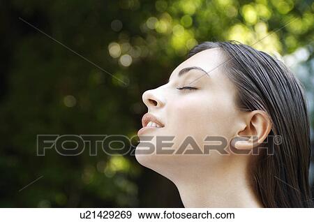 Young woman with closed eyes in forest, close up of head View Large Photo Image Stock Photo - Young woman with closed eyes in forest, close up of head. Fotosearch