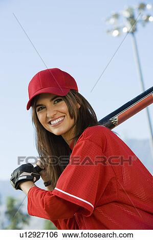 Stock Photograph - Young woman with softball bat, portrait. Fotosearch