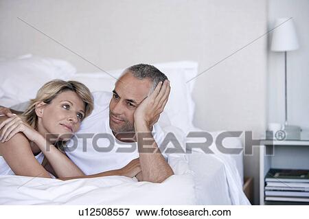 Affectionate couple lying in bed View Large Photo Image Stock Photo - Affectionate couple lying in bed. Fotosearch